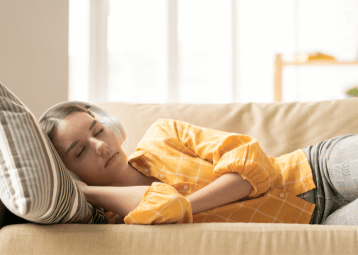 woman sleeping on the couch and listening to music